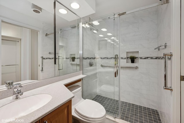 bathroom featuring vanity, toilet, and an enclosed shower