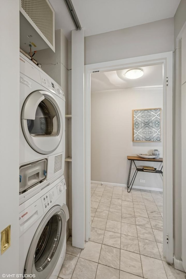 clothes washing area featuring stacked washer / dryer and light tile patterned floors