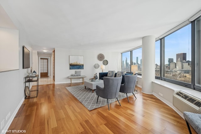 living room featuring a wall mounted AC and light hardwood / wood-style floors