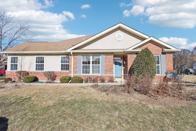 ranch-style house featuring brick siding, roof with shingles, and a front lawn