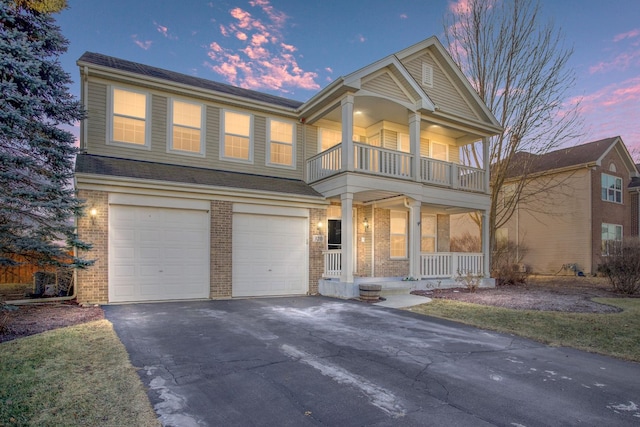 view of front of house with a garage, a balcony, and a porch