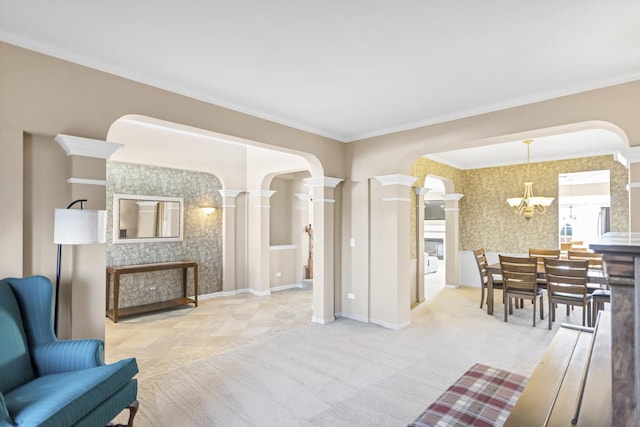 sitting room featuring decorative columns, ornamental molding, light colored carpet, and a notable chandelier