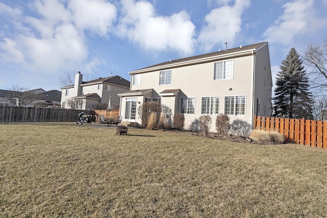 back of property featuring a lawn and a fire pit