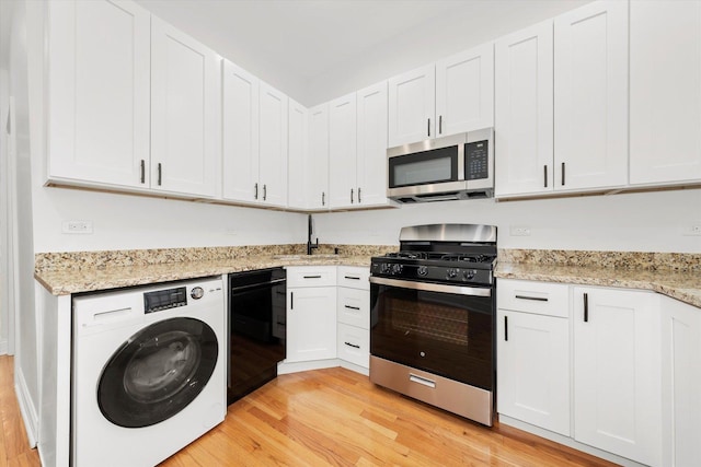 kitchen with washer / clothes dryer, white cabinetry, appliances with stainless steel finishes, and light hardwood / wood-style floors