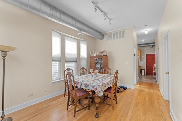 dining space featuring track lighting, light hardwood / wood-style flooring, and a wealth of natural light