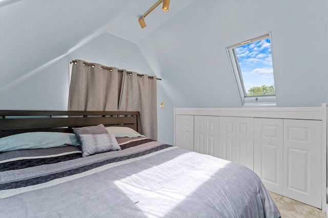 carpeted bedroom featuring vaulted ceiling and a closet