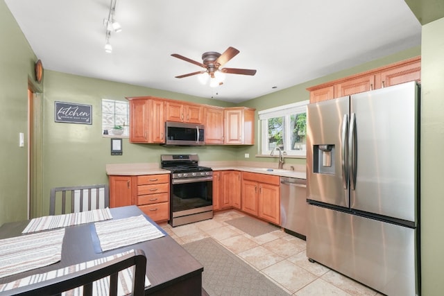 kitchen with sink, stainless steel appliances, ceiling fan, and light tile patterned flooring