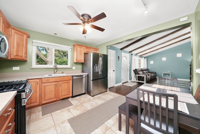 kitchen featuring light tile patterned flooring, sink, lofted ceiling with beams, ceiling fan, and stainless steel appliances