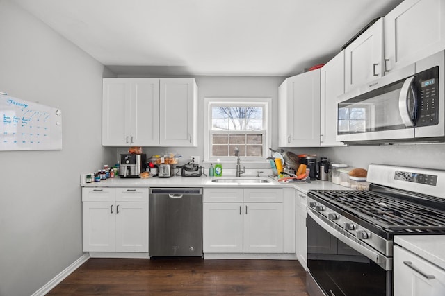 kitchen featuring white cabinetry, stainless steel appliances, dark wood-type flooring, and sink