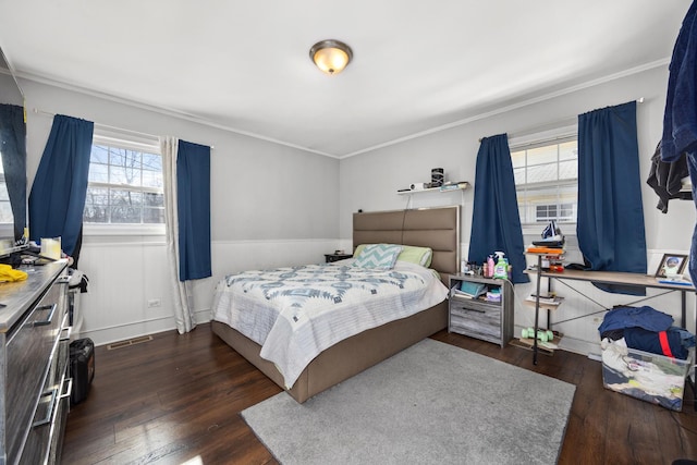 bedroom with ornamental molding, dark hardwood / wood-style flooring, and multiple windows