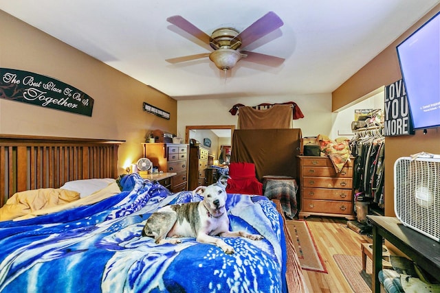 bedroom with wood-type flooring, ceiling fan, and a closet