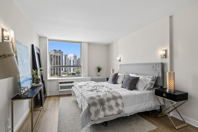 bedroom featuring wood-type flooring and a wall mounted AC