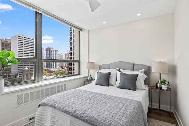 bedroom with radiator, wood-type flooring, and ceiling fan