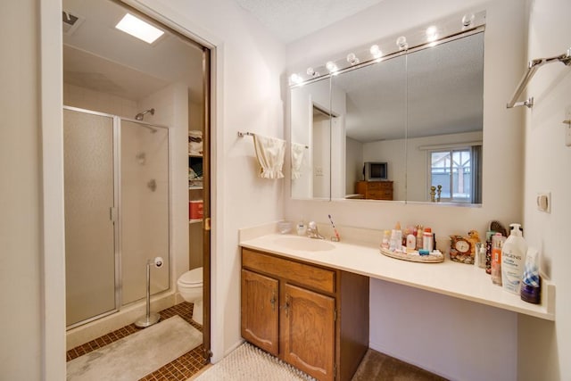 bathroom with vanity, tile patterned floors, toilet, and walk in shower