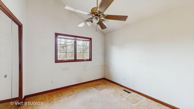 carpeted spare room featuring ceiling fan and vaulted ceiling