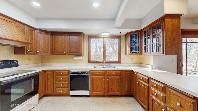 kitchen featuring range with electric stovetop, a wealth of natural light, black dishwasher, and sink