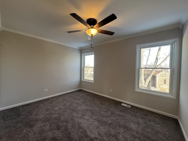 empty room with dark carpet, ornamental molding, and ceiling fan