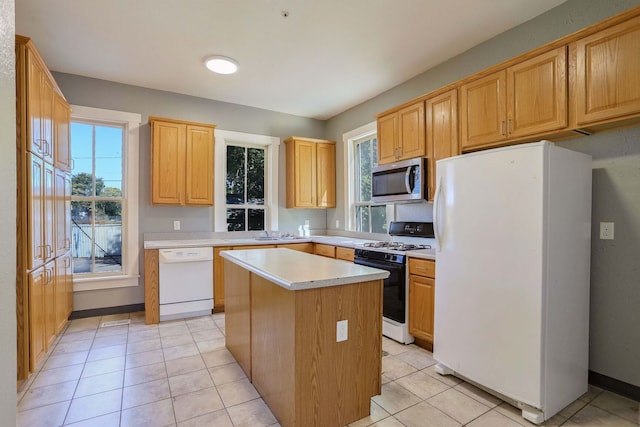 kitchen featuring white appliances, a center island, and light tile patterned floors