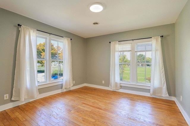 unfurnished room featuring plenty of natural light and light hardwood / wood-style floors