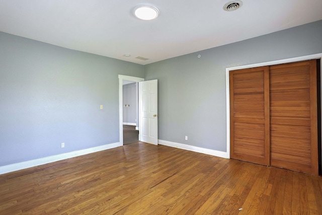 unfurnished bedroom with wood-type flooring and a closet