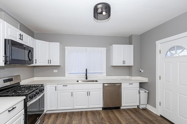 kitchen with white cabinetry, appliances with stainless steel finishes, sink, and dark wood-type flooring