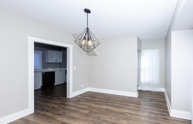 unfurnished dining area featuring dark hardwood / wood-style flooring and a notable chandelier