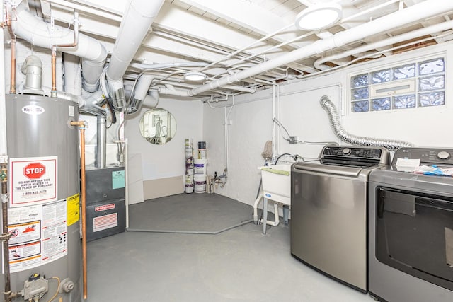 clothes washing area with washer and dryer, sink, and water heater