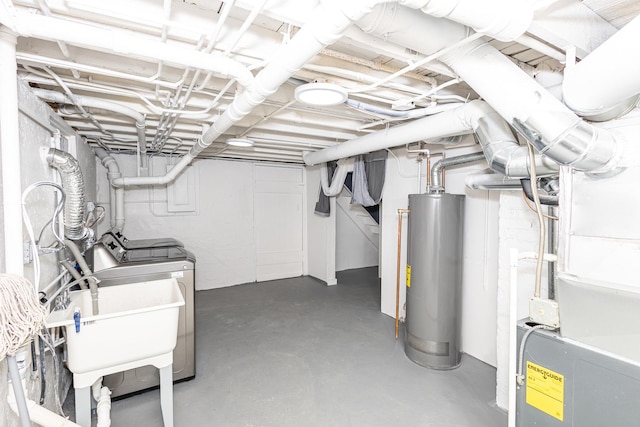 basement featuring water heater, sink, heating unit, and washer and clothes dryer