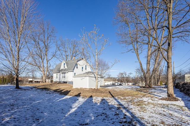 view of snowy exterior with a storage shed