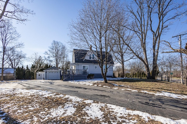 view of front of home with a garage, a wooden deck, and an outdoor structure