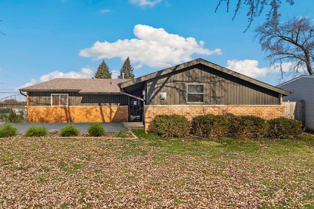 ranch-style house with a patio and a front lawn