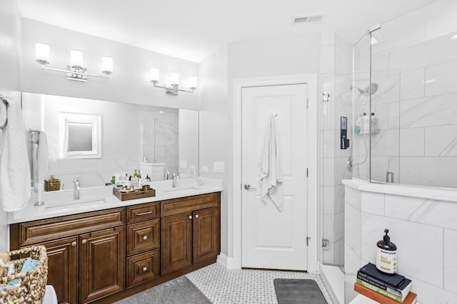 full bath with double vanity, a stall shower, visible vents, and a sink