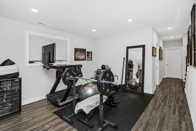 exercise area with baseboards, visible vents, wood finished floors, and recessed lighting