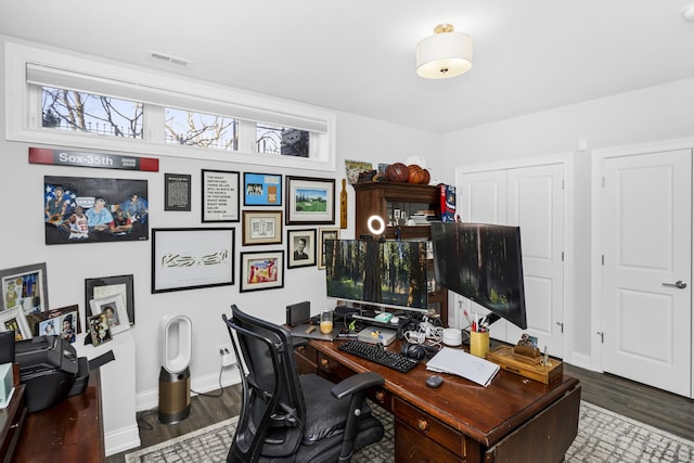 home office featuring visible vents, baseboards, and wood finished floors