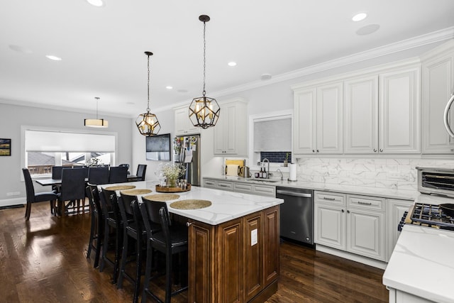 kitchen with tasteful backsplash, a kitchen island, ornamental molding, dark wood-type flooring, and stainless steel appliances