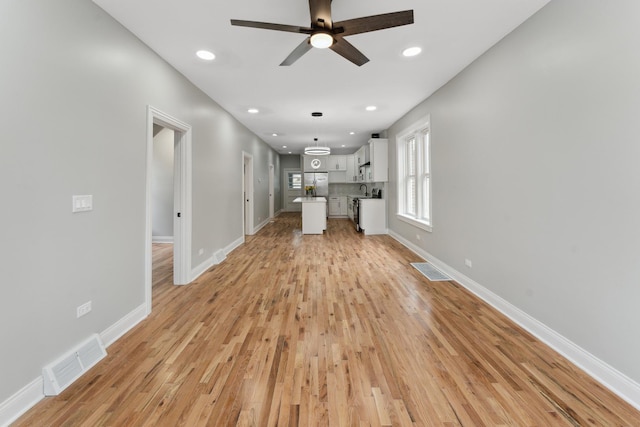 unfurnished living room featuring ceiling fan and light hardwood / wood-style floors