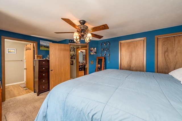 carpeted bedroom with multiple closets and ceiling fan