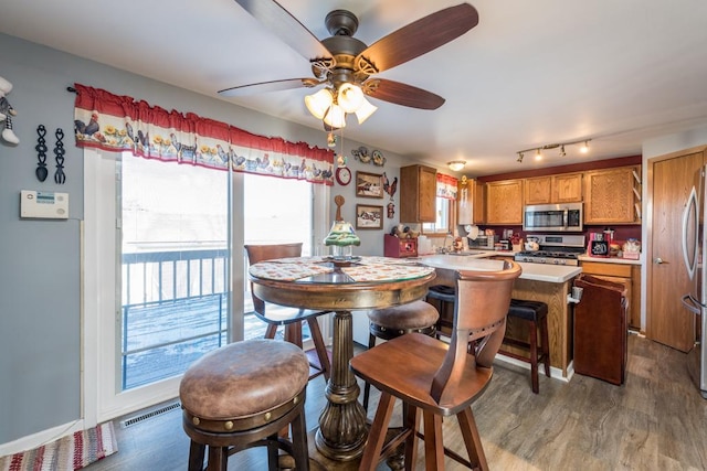 dining space featuring hardwood / wood-style flooring, sink, and ceiling fan