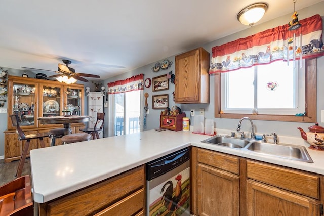 kitchen with ceiling fan, stainless steel dishwasher, kitchen peninsula, and sink