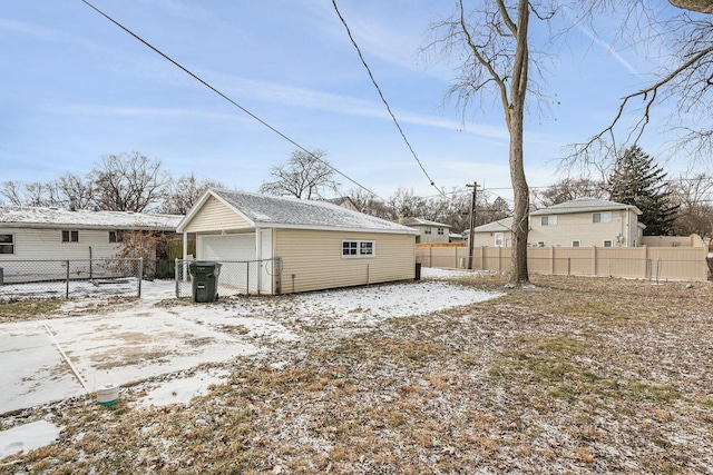 view of snowy exterior featuring a garage and an outdoor structure