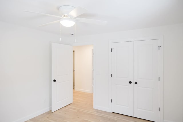 unfurnished bedroom featuring ceiling fan, a closet, and light wood-type flooring