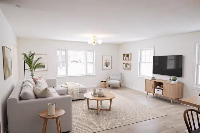 living room featuring plenty of natural light, a notable chandelier, and light hardwood / wood-style floors