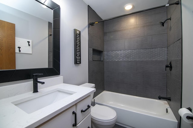 full bathroom featuring tiled shower / bath combo, vanity, and toilet