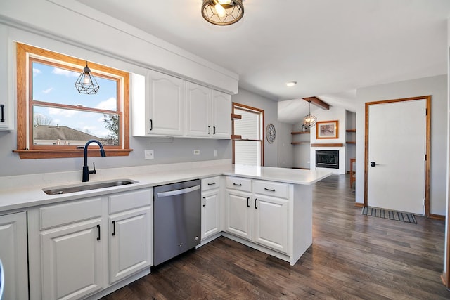 kitchen with sink, white cabinetry, stainless steel dishwasher, kitchen peninsula, and pendant lighting