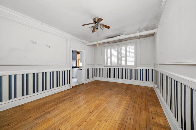 empty room featuring crown molding, light hardwood / wood-style floors, and ceiling fan