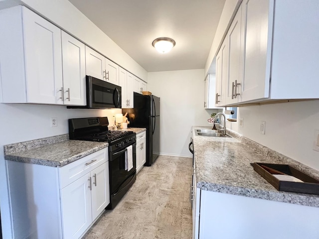 kitchen featuring light stone countertops, sink, white cabinets, and black appliances