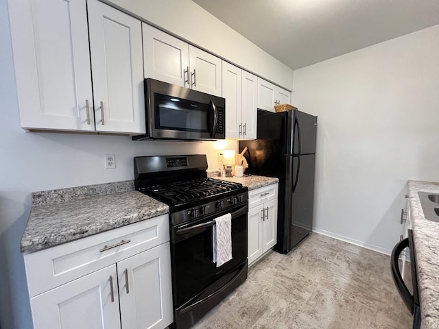 kitchen featuring white cabinets, light stone countertops, and black appliances