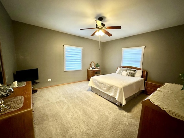 carpeted bedroom featuring multiple windows and ceiling fan