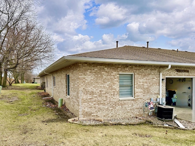 view of side of home with a lawn and central air condition unit