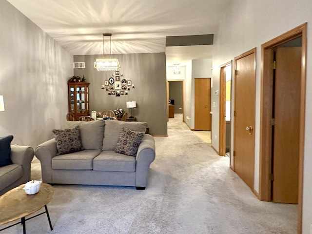 carpeted living room with a notable chandelier